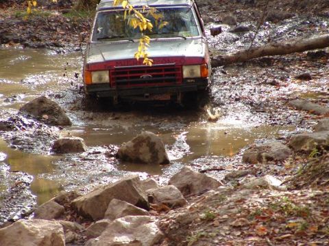 1977 Ford F-150 - This vehicle is navigating a challenging off-road course with water and debris.
