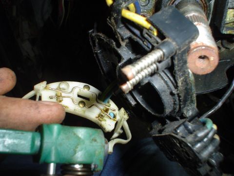 1984 Ford Bronco - A close-up view of a vehicle's steering column electrical connector, showing intricate wiring and spring mechanisms during a rebuild.