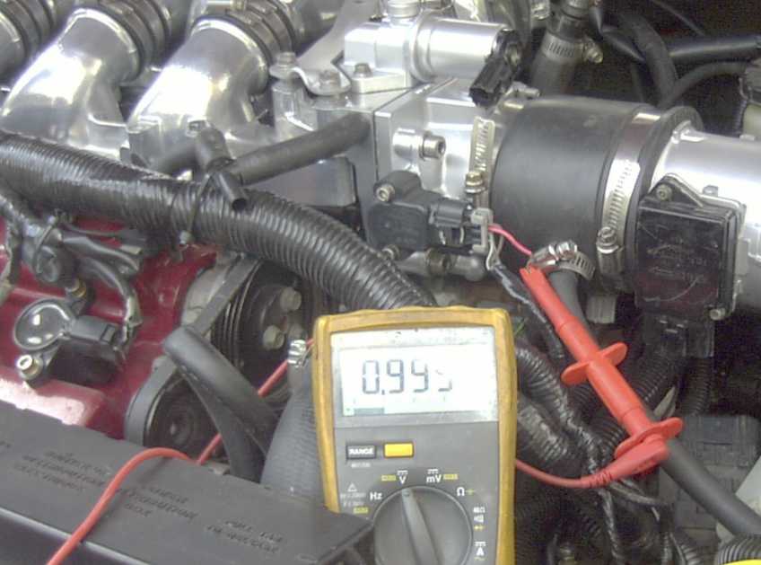 Engine bay with multimeter reading 0.995, connected to sensors