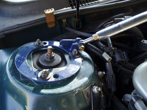 1993 Ford Taurus - Aftermarket strut tower brace installed on a vehicle's suspension system.