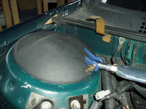 1993 Ford Taurus - Close-up of a strut tower brace installation on a vehicle's shock tower.