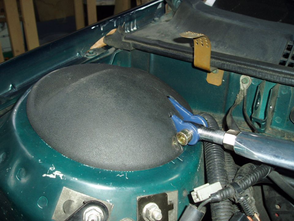 Aftermarket strut tower brace attached to a vehicle's shock tower