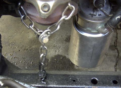1997 Ford Taurus - A chain is used to support a vehicle's exhaust pipe, attached to the frame.