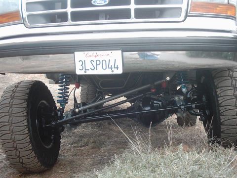 1978 Ford Bronco - Modified front suspension and tire on a lifted truck with a California license plate.