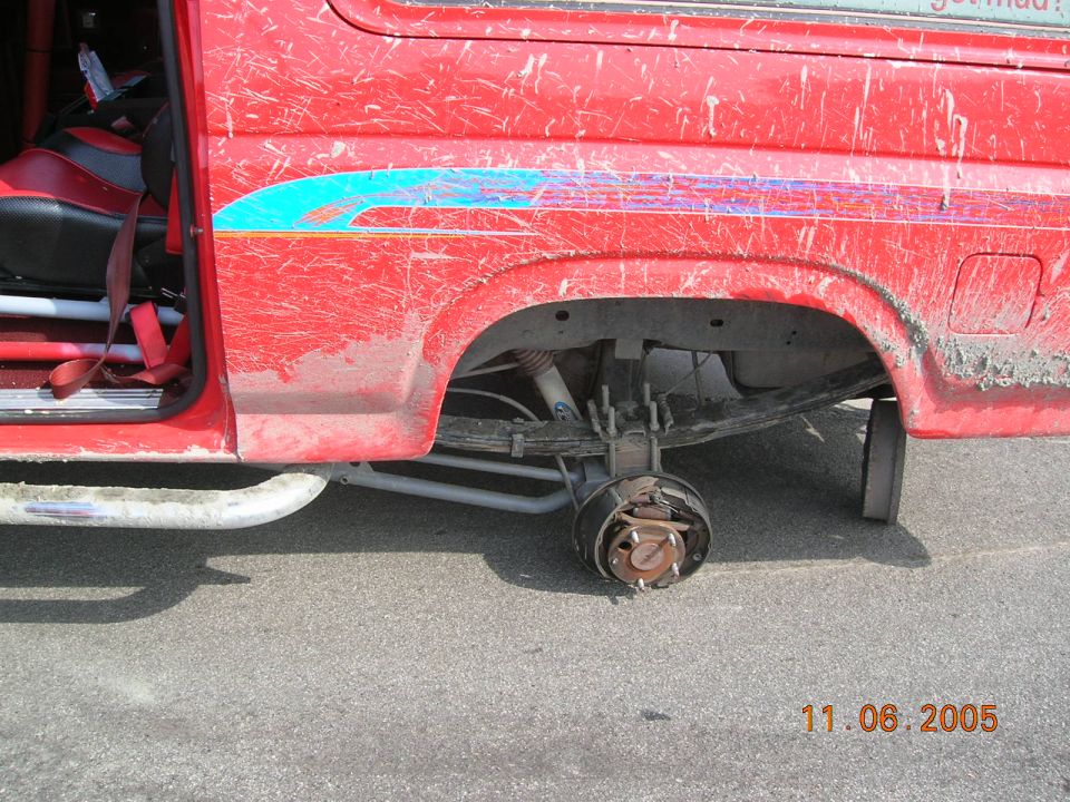 Red van, missing rear wheel, with racing seats visible inside