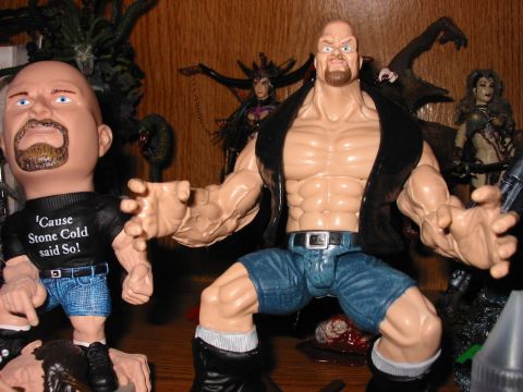 1991 Ford Bronco - A collection of action figures, including one resembling Stone Cold Steve Austin, are displayed on a wooden shelf.