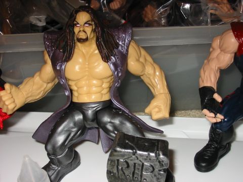 1991 Ford Bronco - Close-up of two wrestling action figures, one in a purple coat, with a tombstone accessory.