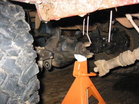 1991 Ford Explorer - The vehicle's undercarriage is visible, with a solid axle swap in progress and supported by an orange jack stand.