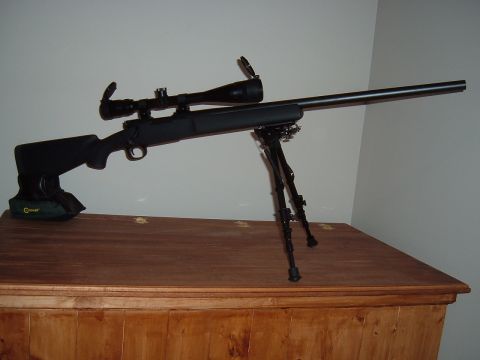 1979 Ford Bronco - A rifle with a scope and bipod rests on a wooden table.