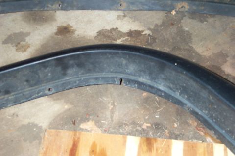 1978 Dodge Power Ram - Close-up of a black plastic fender trim piece, showing wear and damage.