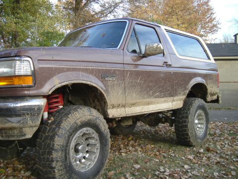 1993 Ford Bronco - Mud-splattered 1993 Ford Bronco shown from a 3/4 front angle.
