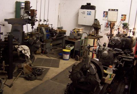 1979 Ford Bronco - A cluttered workshop filled with various pieces of heavy machinery and tools.
