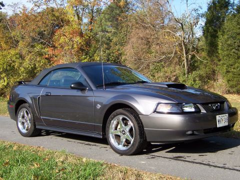 2004 Ford Mustang - A 2004 Ford Mustang convertible is shown from the front three-quarter view on a paved road.