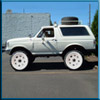 1993 Ford Bronco - This 1993 Ford Bronco is shown in a side profile, custom white wheels and a spare tire mounted on the roof.