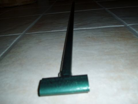 1993 Ford Taurus - A green strut tower brace is shown lying on a tiled floor.