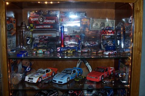 1987 Ford Bronco - A collection of model cars and racing memorabilia is displayed in a wooden cabinet.