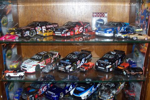 1987 Ford Bronco - Various model cars are displayed on wooden shelves, some racing decals and sponsor names.