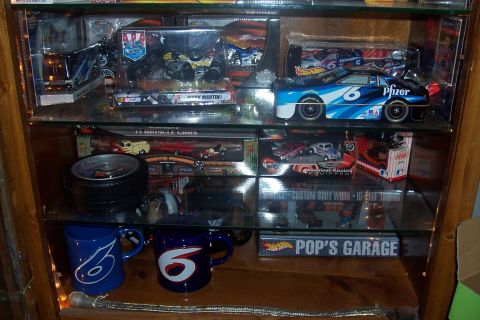 1987 Ford Bronco - A display cabinet holds various model cars, including a Pfizer sponsored NASCAR car, and other collectibles.