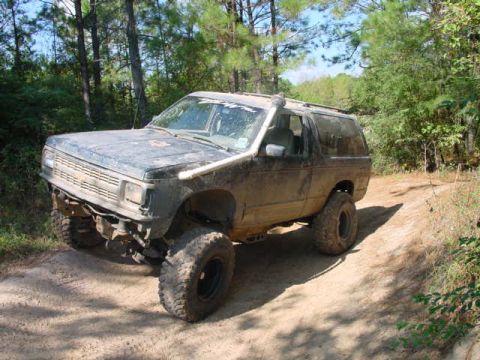1992 Chevrolet S10 - Muddy 1992 Chevrolet S10 Blazer navigating a wooded trail.