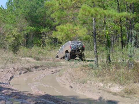 1992 Chevrolet S10 - Off-road vehicle stuck in mud on a wooded trail.