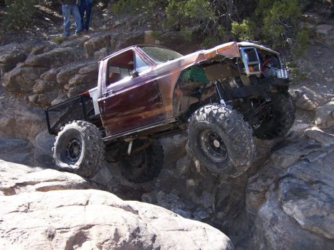 1981 Ford Bronco - This heavily modified truck, likely from the early 1980s, is shown tackling a rocky terrain.