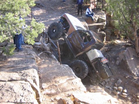 1981 Ford Bronco - This off-road vehicle appears to be stuck on a steep, rocky trail, with onlookers observing the situation.