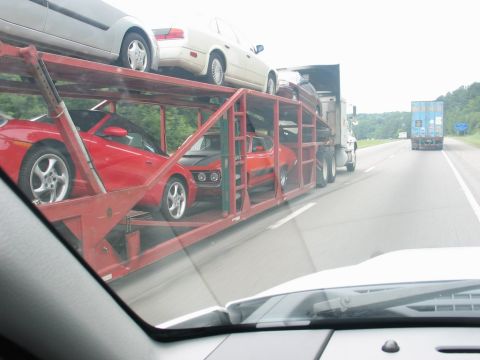 2004 Ford F-150 - A car carrier truck transports multiple vehicles on the highway.