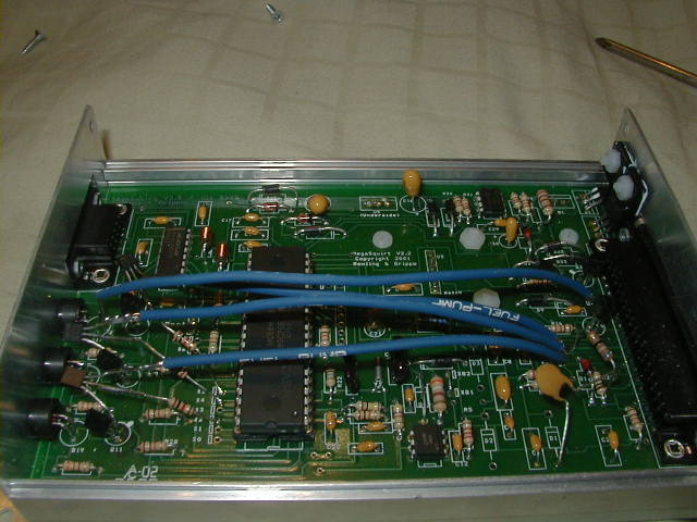 circuit board with blue wires and chips inside metal casing, text reads 'FUEL-PUMP'