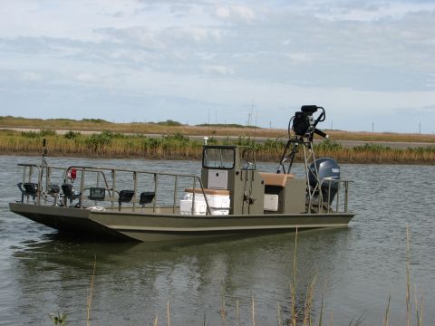 1989 Ford Bronco - A flat-bottom boat equipped with an outboard motor and a camera rig is shown on the water.