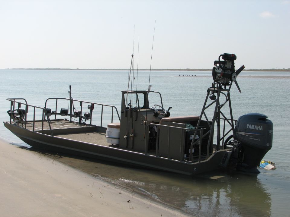 Boat with Yamaha outboard motor on the stern, parked on a sandy shore