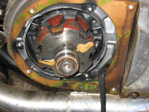 1997 Yamaha YT60 Tri-Moto - Close-up view of an engine rotor red magnets and yellow sealant, part of a motorcycle's internal mechanics.