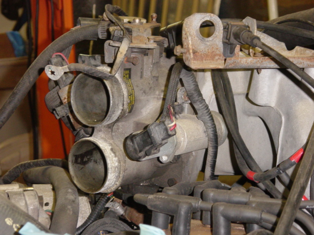 Throttle body.  My manifold was so thoroughly coated with combustion byproducts and blowby via the PCV, you probably wouldn't want to light a match anywhere near here.