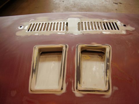 1997 Ford Taurus - A car hood is shown with body filler around two scoops and a vent grille, indicating repair or modification.