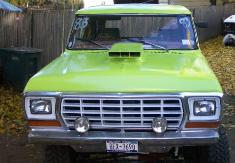 1978 Ford Bronco - Front view of a lime green 1978 Ford Bronco a prominent hood scoop and "83" markings on the windshield.
