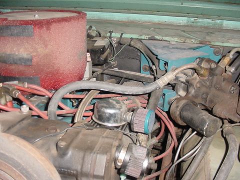 1969 Ford Bronco - Close-up view of engine components including a prominent red air filter and various hoses and wires.