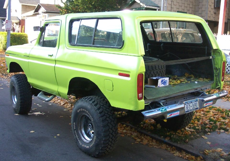 Lifted lime green SUV with rear gate open, spare tire inside. License plate reads GEX-3690