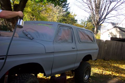 1978 Ford Bronco - A 1978 Ford Bronco is being prepped for a new paint job with a spray gun.