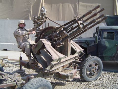 1996 Ford Bronco - A soldier operates a mounted Gatling gun, with a military truck visible behind it.