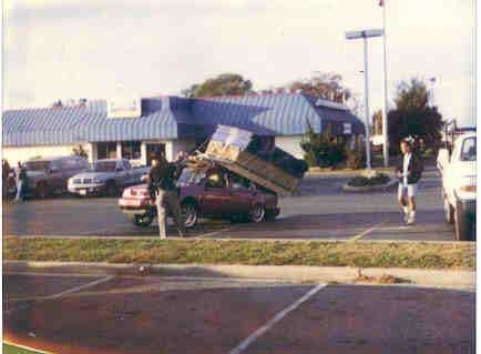 1992 Ford Taurus - A 1992 Ford Taurus is seen with a large load of furniture strapped precariously to its roof.