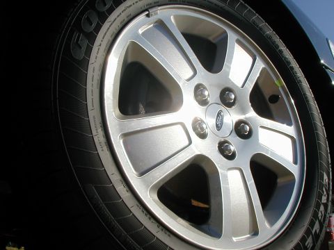 2000 Ford Crown Victoria - A close-up view of a vehicle's wheel and tire, a Ford emblem on the hub.