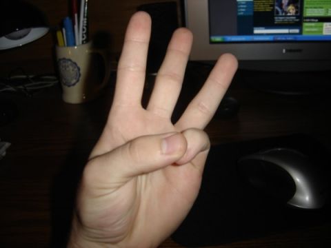 1999 Ford Taurus - A hand displays three fingers against a backdrop of a computer setup and office supplies.