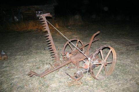 2003 Jeep TJ - This antique farm implement is covered in rust and appears to be in disrepair.