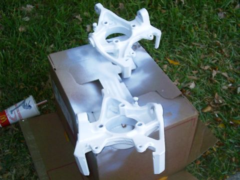 1986 Ford Bronco - Two white painted suspension parts are drying on a cardboard box outdoors next to a McDonald's cup.