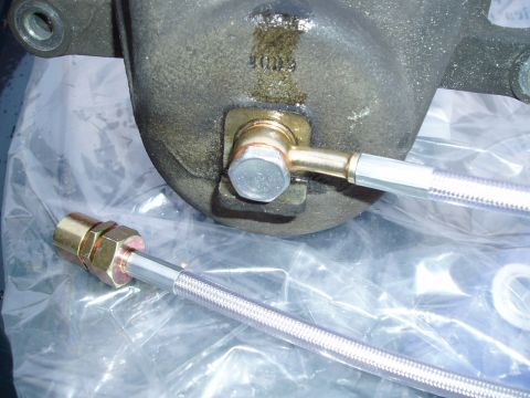 1993 Ford Taurus - A close-up view of a brake caliper part with a braided hose connected, indicating a brake upgrade.