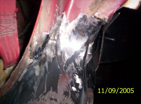 1985 Ford Bronco - Close-up of damaged and repaired metalwork, with a red strap visible.