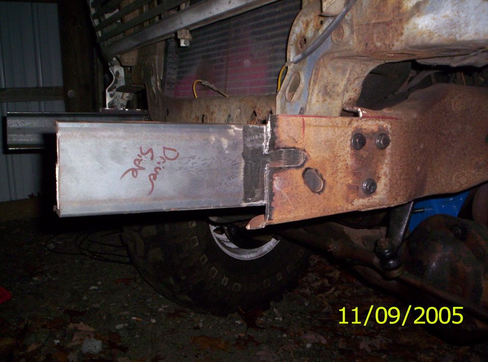 Welded steel tube extension on rusty frame with 'Drive Side' written in red marker