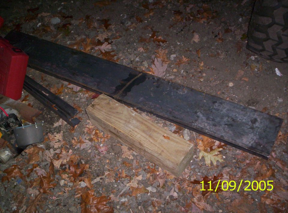 Tire tread and debris on the ground, with a wooden block and metal bar