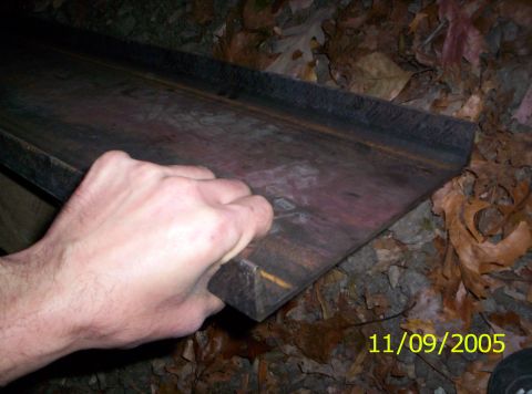 1985 Ford Bronco - A hand grips a dark metal object, possibly a vehicle part, with a Supermotors.net watermark and date visible.