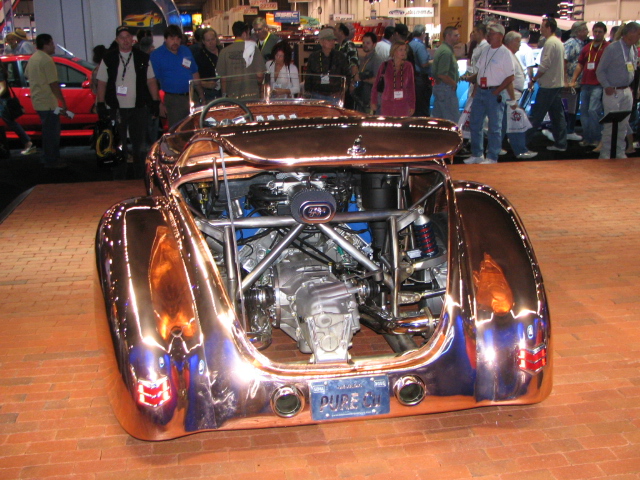 Copper-plated custom hot rod with exposed engine and transmission, viewed from the rear