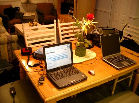 1994 Ford Probe - A domestic scene shows two laptops and a bag on a table, with a flower arrangement as a centerpiece.